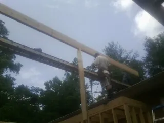 Carpenter setting a ridge beam over a new addition frame — Ice Dam Removal by Roofing Brothers in Wrightsboro