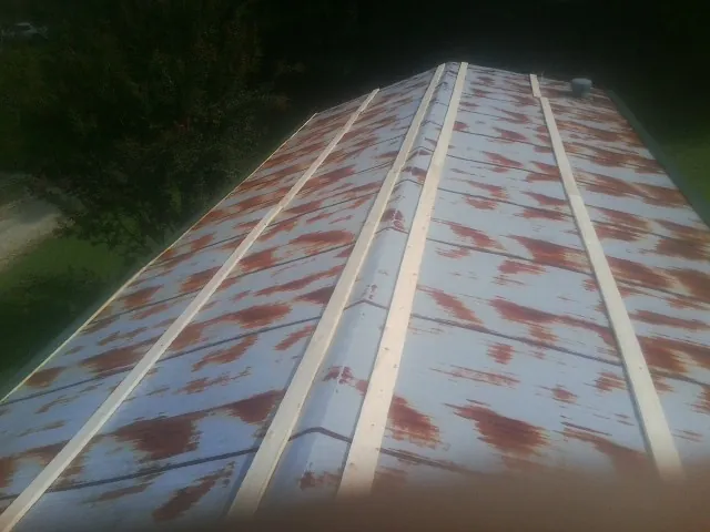 Rusted metal roof panels with new wood purlins before replacement — Storm Damage Roof Repair in Wrightsboro by Roofing Brothers
