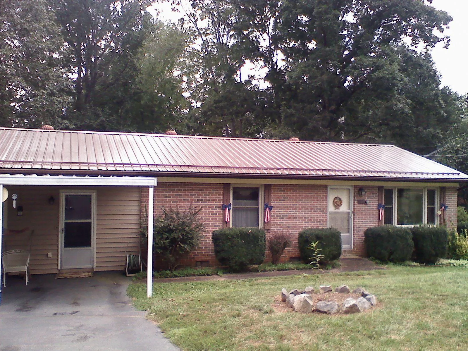 Bronze metal roof and carport on a brick ranch home — Roof Repair work by our crew in Wrightsboro